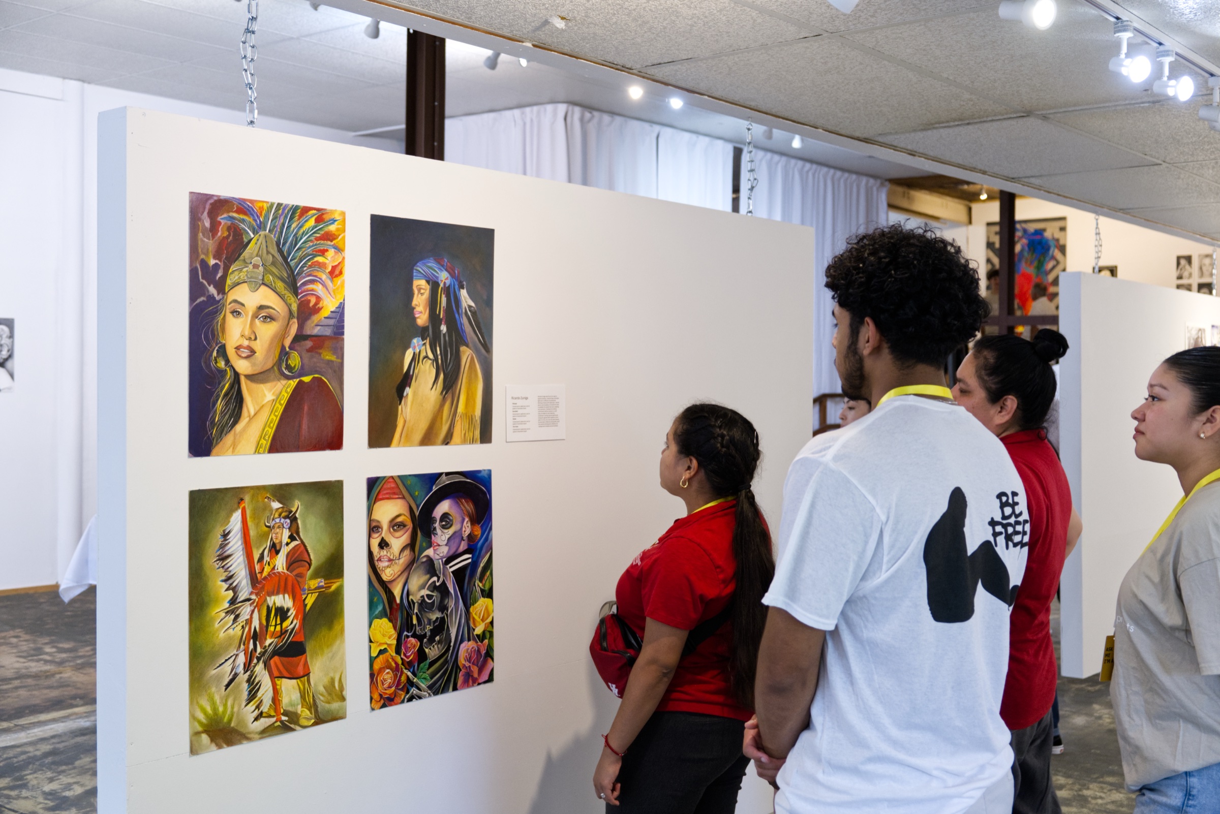 Visitors viewing portrait paintings at a Be Free Gallery show